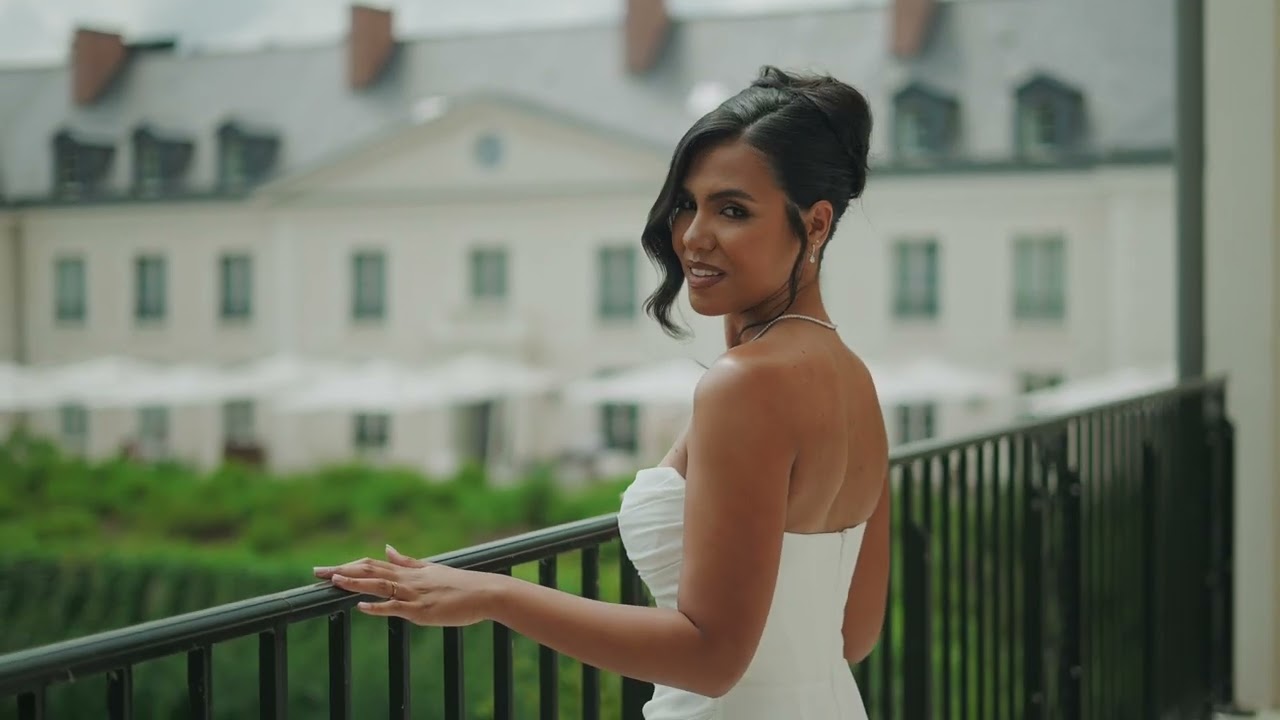 A bride turns towards the camera beside a balustrade